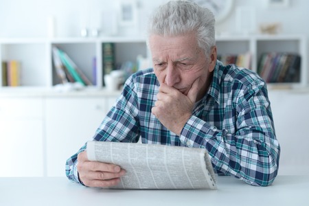 Senior man at homesenior man reading newspaper at homeの写真素材