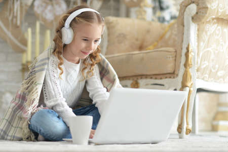 Portrait of teenage girl in headphones using laptop