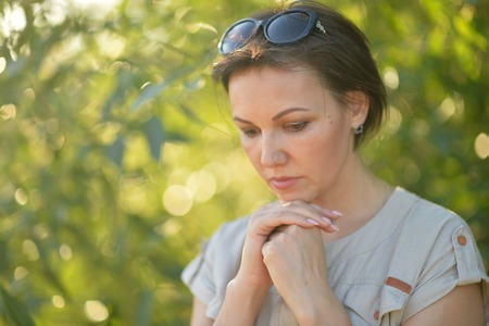 Portrait of a beautiful sad young woman outdoorsの写真素材