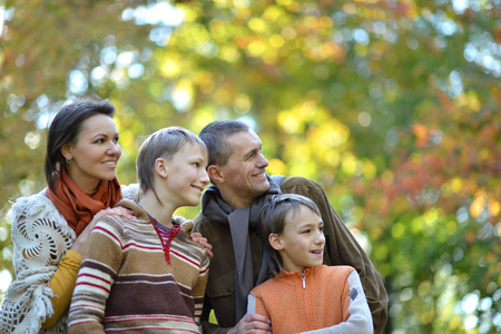 Family of four walking in autumn park