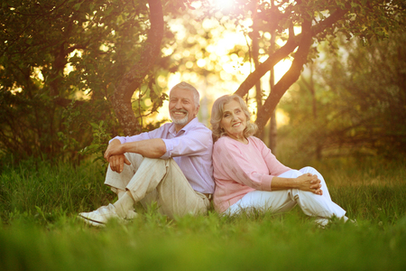 Portrait of happy senior couple resting in spring parkの写真素材
