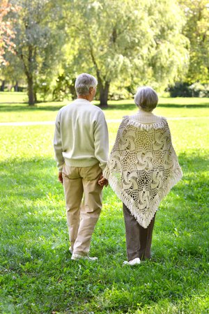 Portrait of senior couple walking in autumn forestの写真素材