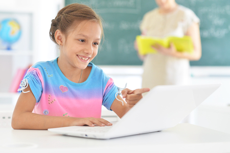 Portrait of emotional little girl using laptopの写真素材