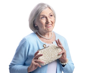 Portrait of a beautiful senior woman posing with purseの写真素材