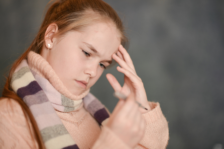 Close-up portrait of ill girl measuring temperatureの写真素材