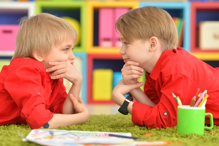 Two smiling boys in red shirts having funの写真素材