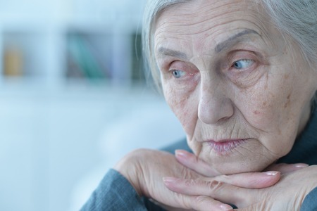Portrait of tired senior woman posing at homeの写真素材