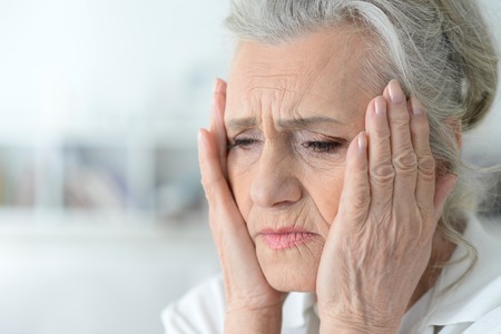Portrait of beautiful Sad senior woman with headacheの写真素材