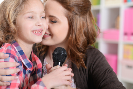 mother and daughter singing karaokeの写真素材