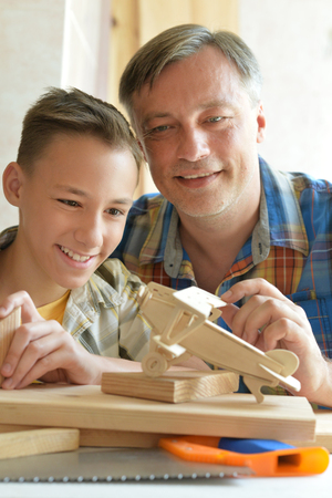 boy with model of ship and handsawの写真素材