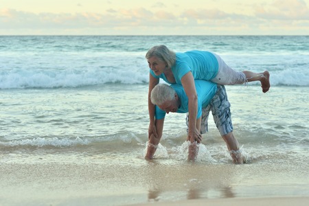 Happy elderly couple resting on  beachの写真素材