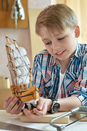 Portrait of cute little boy working with wood in workshopの写真素材
