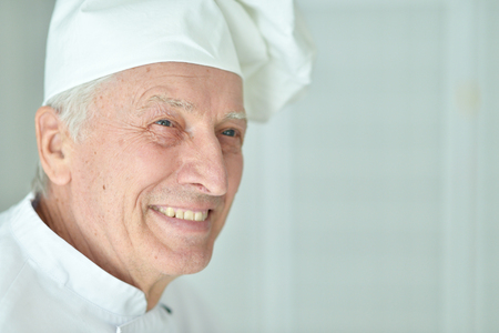 Portrait of happy elderly male chef posing at homeの写真素材