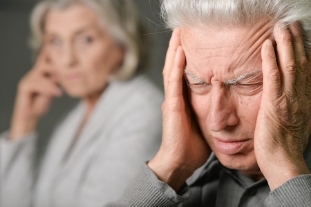 Senior man with headache holdingの写真素材