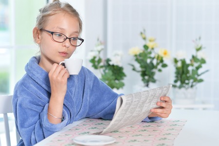 Cute girl in eyeglasses and blue bathrobeの写真素材