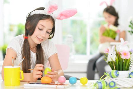 Portrait of cute girl painting eggs for Easter holidayの写真素材