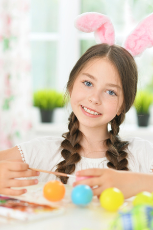 Portrait of cute girl painting eggs for Easter holidayの写真素材
