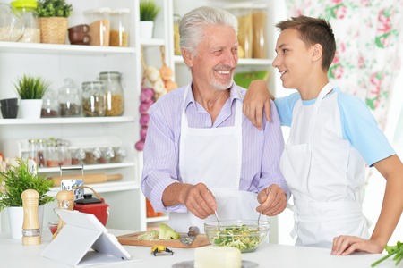 Senior man with grandson preparing dinner in kitchenの写真素材
