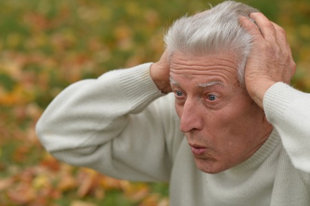 Close-up portrait of thoughtful senior man in parkの写真素材