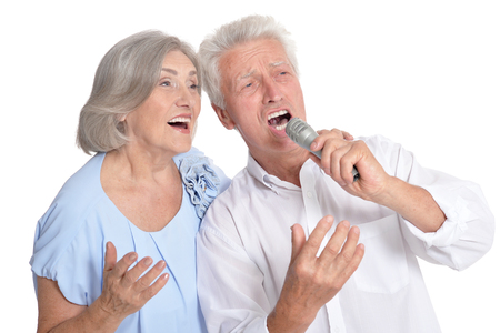 Senior couple singing karaoke isolatedの写真素材
