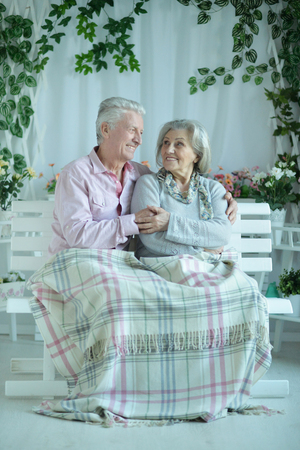Portrait of couple sitting on wooden benchの写真素材
