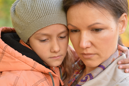 Close up portrait of mother hugging daughter outdoorsの写真素材
