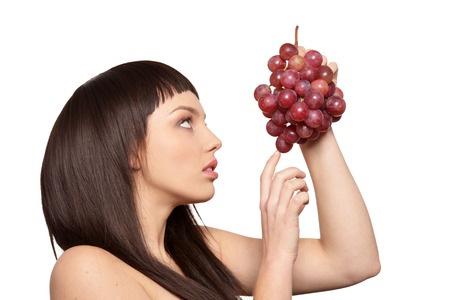 Young woman posing with grapes isolated on white backgroundの写真素材