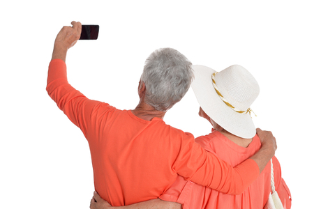 Senior couple taking selfie isolated on white backgroundの写真素材