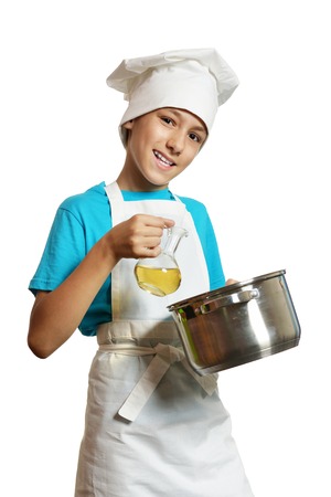 Portrait of little boy wearing chef uniform on white backgroundの写真素材