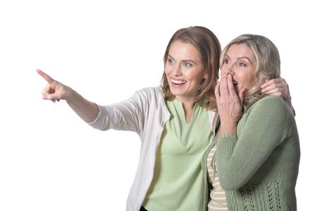 Portrait senior woman with daughter pointing on white background