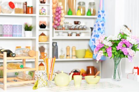 Yellow tableware and flowers on a kitchen tableの写真素材