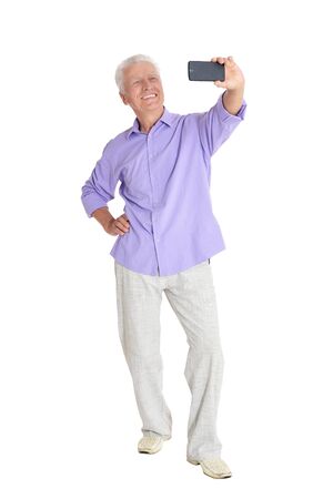 senior man taking selfie on white backgroundの写真素材