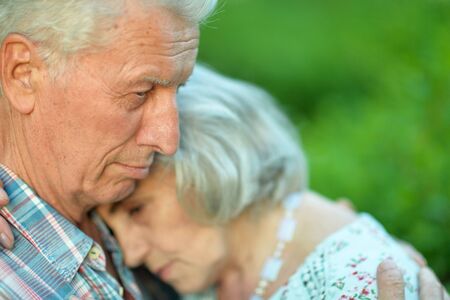 Unhappy senior couple posing in the summer parkの写真素材