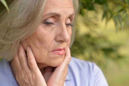 Portrait of sad senior woman in parkの写真素材