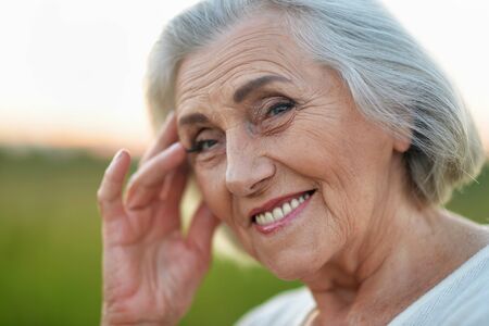 Close up portrait of happy senior woman in park