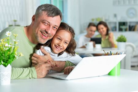 Portrait of father with little daughter using laptop