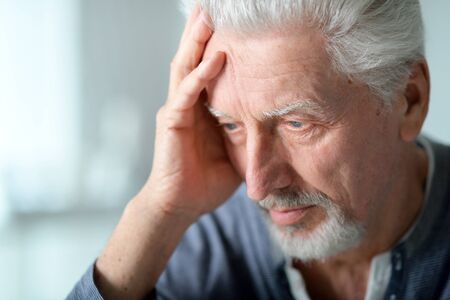 Portrait of thoughtful senior man at homeの写真素材