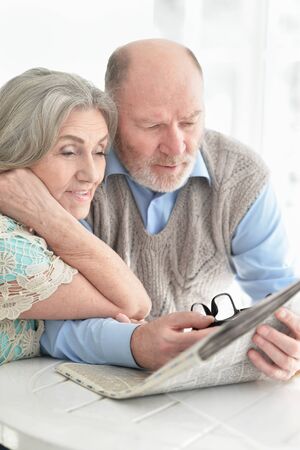 Portrait of a senior couple with newspaper at home