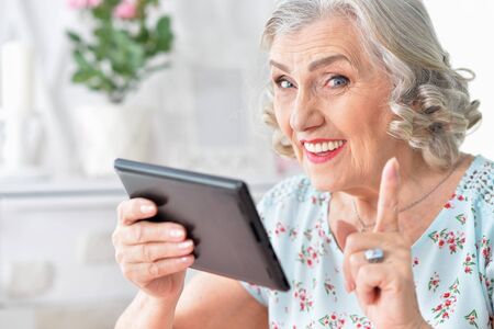 Portrait of Old woman with tablet pc
