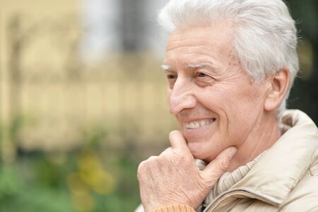 Close up portrait of happy senior man in park