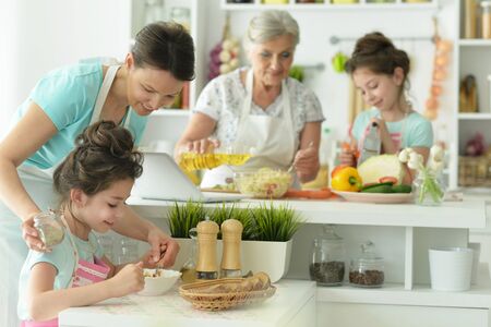 Happy family delicious fresh salad in kitchen