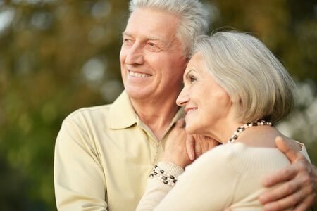 Portrait of smiling senior couple in autumn parkの写真素材