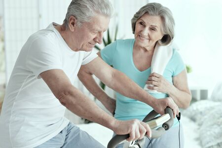 Active smiling senior couple exercising in gymの写真素材