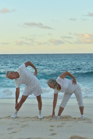 Portrait of fit senior couple exercising by seaの写真素材