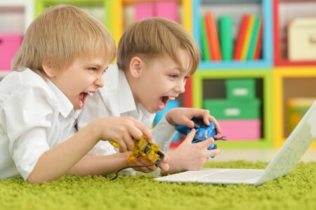 Portrait of two boys playing computer gamesの写真素材
