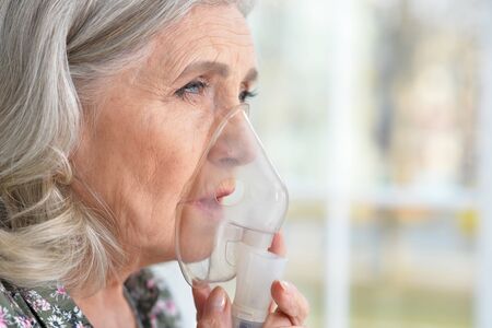 Close up portrait of elderly woman with flu inhalation