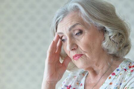 Portrait of sad senior woman at home