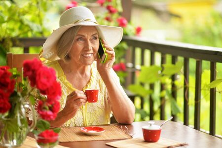 Portrait of a happy aged woman drinking coffee