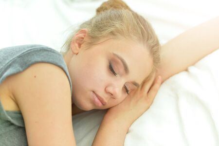 Portrait of young woman sleeping in bed at homeの写真素材