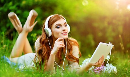 Beautiful young woman lying on green meadowの写真素材